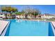 Community pool with clear blue water, surrounded by lounge chairs and trees at 3242 S Semoran Blvd # 21, Orlando, FL 32822