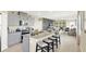 Open-concept kitchen with gray cabinetry, granite countertops, a large center island and stool seating at 3633 Salvia Ct, Tavares, FL 32778