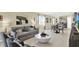 Open-concept living area with gray sofa, round coffee table, and dining space with stainless steel refrigerator at 3633 Salvia Ct, Tavares, FL 32778