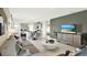 Open-concept living room and kitchen featuring modern decor, tile floors, and neutral tones at 3633 Salvia Ct, Tavares, FL 32778