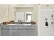 Bathroom with dual sinks, granite countertop, gray cabinets and shower with curtain at 3639 Salvia Ct, Tavares, FL 32778