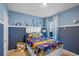 Cozy bedroom featuring an ocean theme, blue walls, and a comfortable bed with colorful bedding at 3893 Diving Dove Ln, Bartow, FL 33830