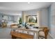Sunlit dining room features neutral tile floor, stylish decor, white table and view to back yard at 3893 Diving Dove Ln, Bartow, FL 33830