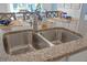 Close up of kitchen island with stainless steel sink, chrome faucet, granite counters and eat in seating at 3893 Diving Dove Ln, Bartow, FL 33830