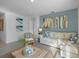 Cozy living area with light blue accent wall, plush sofa, and decorative coastal artwork at 3893 Diving Dove Ln, Bartow, FL 33830