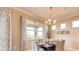 Formal dining area showcasing a chandelier and large window providing ample natural light at 3965 Kennebunk Loop, Mount Dora, FL 32757
