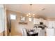 Elegant dining area with a chandelier, adjacent to the kitchen and featuring three windows for natural light at 3965 Kennebunk Loop, Mount Dora, FL 32757