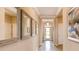 Bright hallway features tile floors, crown molding, multiple mirrors, and a front door letting in natural light at 3965 Kennebunk Loop, Mount Dora, FL 32757