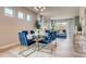 Bright dining area with modern chandelier, large windows, and open concept living space at 3971 Kennebunk Loop, Mount Dora, FL 32757