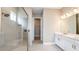 Bathroom featuring a walk-in shower, dual vanities, and modern finishes, creating a spa-like experience at 4197 Barbuda Ln, Kissimmee, FL 34758