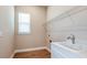 Functional laundry room with wood-look tile, a utility sink, and shelving for storage at 4197 Barbuda Ln, Kissimmee, FL 34758