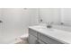Modern bathroom featuring a sleek vanity with gray cabinetry and a walk-in shower with white subway tile at 4203 Barbuda Ln, Kissimmee, FL 34758