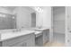 Contemporary bathroom with double vanities featuring gray cabinets, quartz countertops, and a large mirror at 4203 Barbuda Ln, Kissimmee, FL 34758