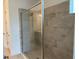 Modern bathroom featuring a glass-enclosed shower with light gray textured tiling and a built-in bench at 4203 Barbuda Ln, Kissimmee, FL 34758