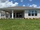 Back exterior of home featuring sliding glass doors and a covered patio overlooking a well-maintained lawn at 4203 Barbuda Ln, Kissimmee, FL 34758