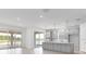 Modern kitchen with gray cabinets, stainless steel appliances, an island and sliding glass doors at 4203 Barbuda Ln, Kissimmee, FL 34758