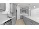 Open-concept kitchen featuring stainless steel appliances, gray cabinets, and a center island at 4203 Barbuda Ln, Kissimmee, FL 34758