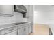 Kitchen featuring white backsplash, stainless steel range hood, and light gray cabinets at 4203 Barbuda Ln, Kissimmee, FL 34758