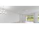 Bright living room featuring sliding glass doors and an elegant chandelier at 4203 Barbuda Ln, Kissimmee, FL 34758