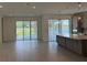 Open-concept living space with tile flooring and sliding glass doors offering scenic lake views at 4203 Barbuda Ln, Kissimmee, FL 34758