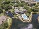 Aerial view of a community with a lake, fountain, and a pool surrounded by lush greenery and residential buildings at 5144 City St # 238, Orlando, FL 32839