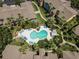 Aerial view of community pool with blue lounge chairs, palm trees, and walkways amidst surrounding buildings at 5144 City St # 238, Orlando, FL 32839