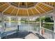 Interior view of a gazebo on a pond with a wooden bench and decorative roof at 5144 City St # 238, Orlando, FL 32839