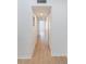 Hallway featuring wood floors, white trim, and storage closets at 5144 City St # 238, Orlando, FL 32839