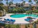 Beautiful community pool area with lounge chairs and tropical landscaping in a well maintained setting at 5144 City St # 238, Orlando, FL 32839
