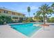 Community pool featuring clear blue water and surrounding palm trees at 5144 City St # 238, Orlando, FL 32839