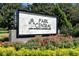 Close up of the community's entrance sign amidst vibrant flowers and greenery at 5144 City St # 238, Orlando, FL 32839