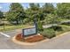 Community entrance sign with attractive landscaping and mature trees, creating a welcoming atmosphere at 5144 City St # 238, Orlando, FL 32839
