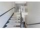 Interior staircase with black metal railings against white siding and concrete steps at 5144 City St # 238, Orlando, FL 32839