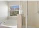 Well-lit bathroom features a separate tub, enclosed shower, and large bright window at 612 Old Pine Ct, Sanford, FL 32773