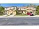 Charming townhome featuring a front lawn, a driveway, an attached garage, and neutral-colored stucco at 612 Old Pine Ct, Sanford, FL 32773