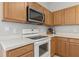 Functional kitchen with white countertops, wood cabinets, and essential appliances at 612 Old Pine Ct, Sanford, FL 32773