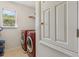 View into a laundry room with side-by-side machines, a window, and storage shelving at 612 Old Pine Ct, Sanford, FL 32773