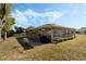 Home exterior with back patio, grill, and well-manicured lawn and landscaping at 6133 Seagull Ln, Lakeland, FL 33809