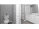 Half bathroom featuring a toilet and vanity with white cabinets at 7699 Sw 74Th Loop, Ocala, FL 34481