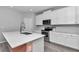 Modern kitchen with white cabinets, stainless steel appliances, spacious countertop and tile flooring at 7699 Sw 74Th Loop, Ocala, FL 34481