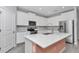 Well-lit kitchen boasts white cabinets, stainless steel appliances, quartz countertops, and a spacious island at 7699 Sw 74Th Loop, Ocala, FL 34481