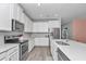 Modern kitchen featuring stainless steel appliances, white cabinets, and quartz countertops at 7699 Sw 74Th Loop, Ocala, FL 34481