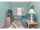 Cozy living room featuring a teal sofa, TV, and soft rug, illuminated by natural light from the window at 7699 Sw 74Th Loop, Ocala, FL 34481