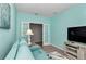 Bright room with teal walls, comfy sofa, TV, and french doors at 7699 Sw 74Th Loop, Ocala, FL 34481