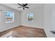 Bright bedroom with wood-look flooring and two windows at 859 Neuse Ave, Orlando, FL 32804