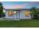 Front exterior of home at dusk, featuring a well-manicured lawn and a lovely palm tree at 859 Neuse Ave, Orlando, FL 32804