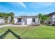 Charming home featuring a well-manicured lawn, a fresh white exterior, and a vibrant palm tree adding to its curb appeal at 859 Neuse Ave, Orlando, FL 32804