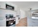 Open-concept kitchen with new appliances, white cabinets, and an adjoining living area at 859 Neuse Ave, Orlando, FL 32804