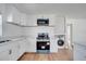 Modern kitchen featuring white cabinets, stainless steel appliances, and wood-look flooring at 859 Neuse Ave, Orlando, FL 32804
