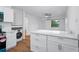 Bright kitchen features an island with a white countertop, cabinets, and modern washer/dryer at 859 Neuse Ave, Orlando, FL 32804